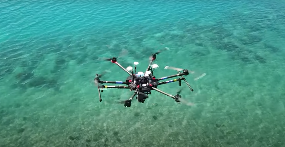 A drone flies over a coral reef, taking photos that will be used in NeMO-Net.