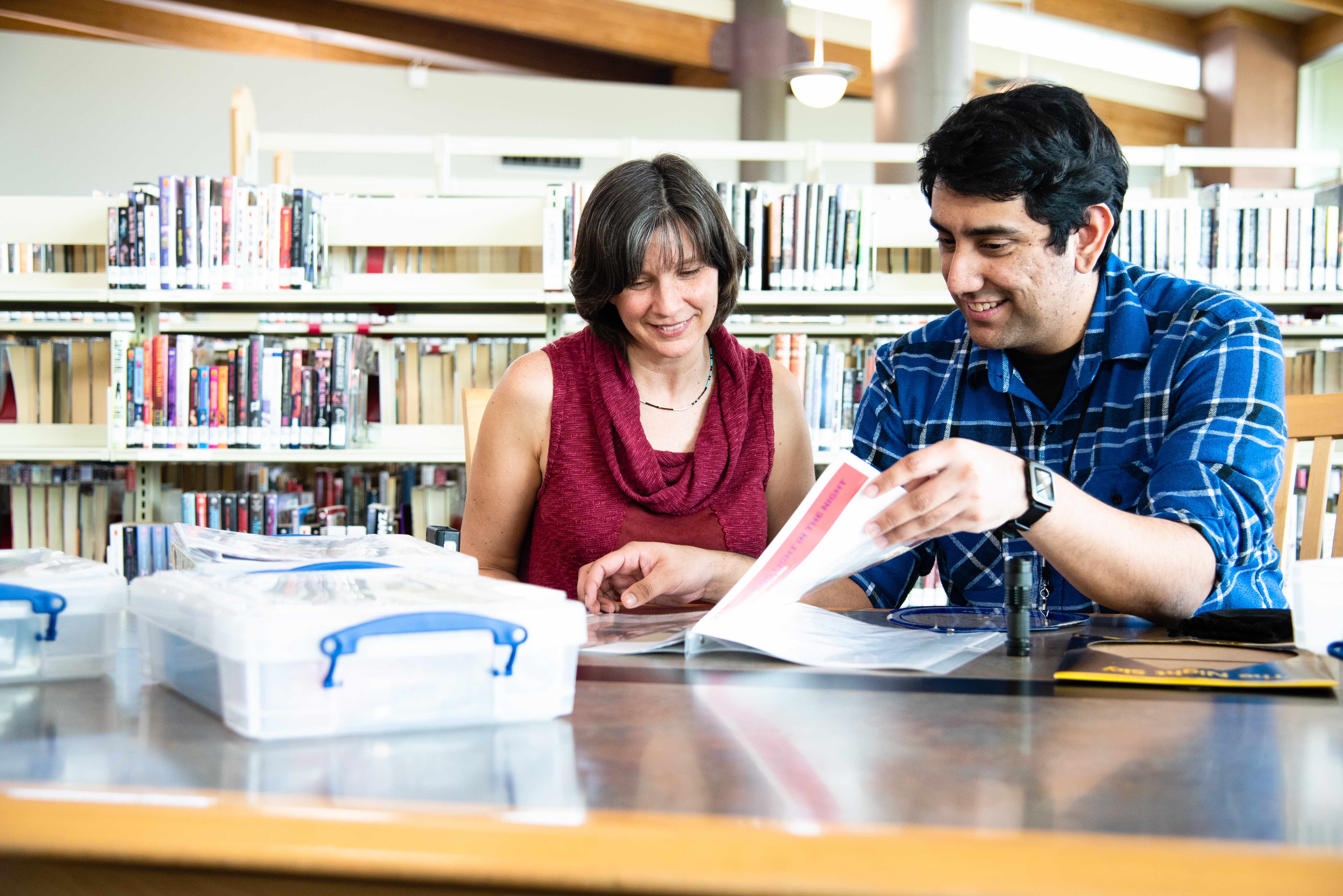 Two people doing citizen science in a library.