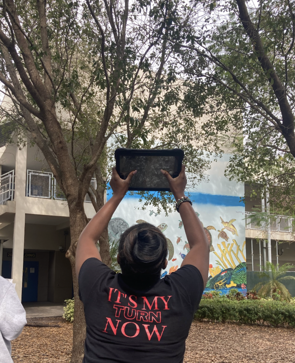Teacher with tablet facing tree for SciStarter project