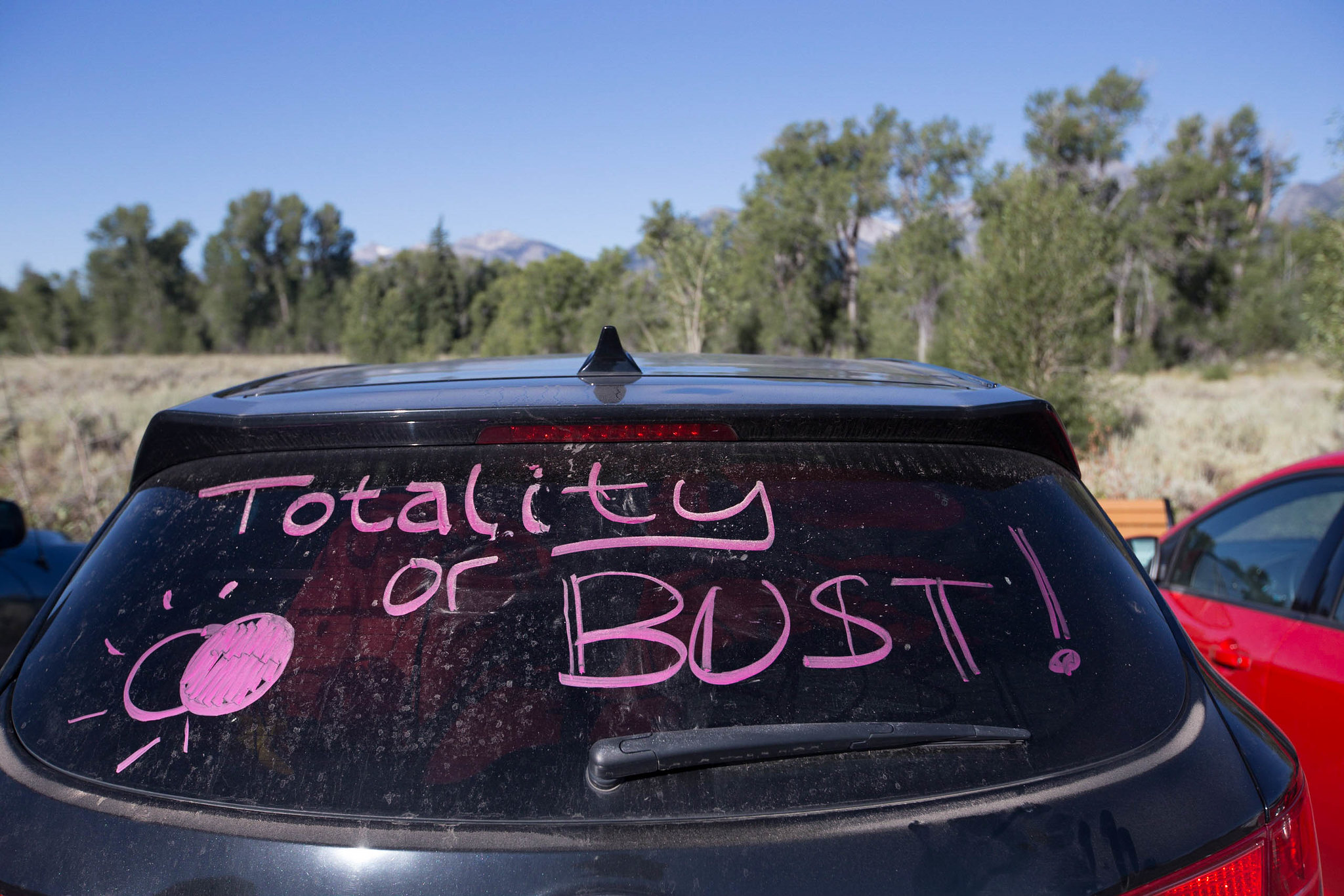 Car windshield with the message "Totality or Bust"