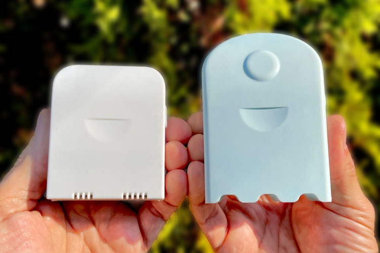 Two small, flat, rectangular plastic AirBeam air monitors