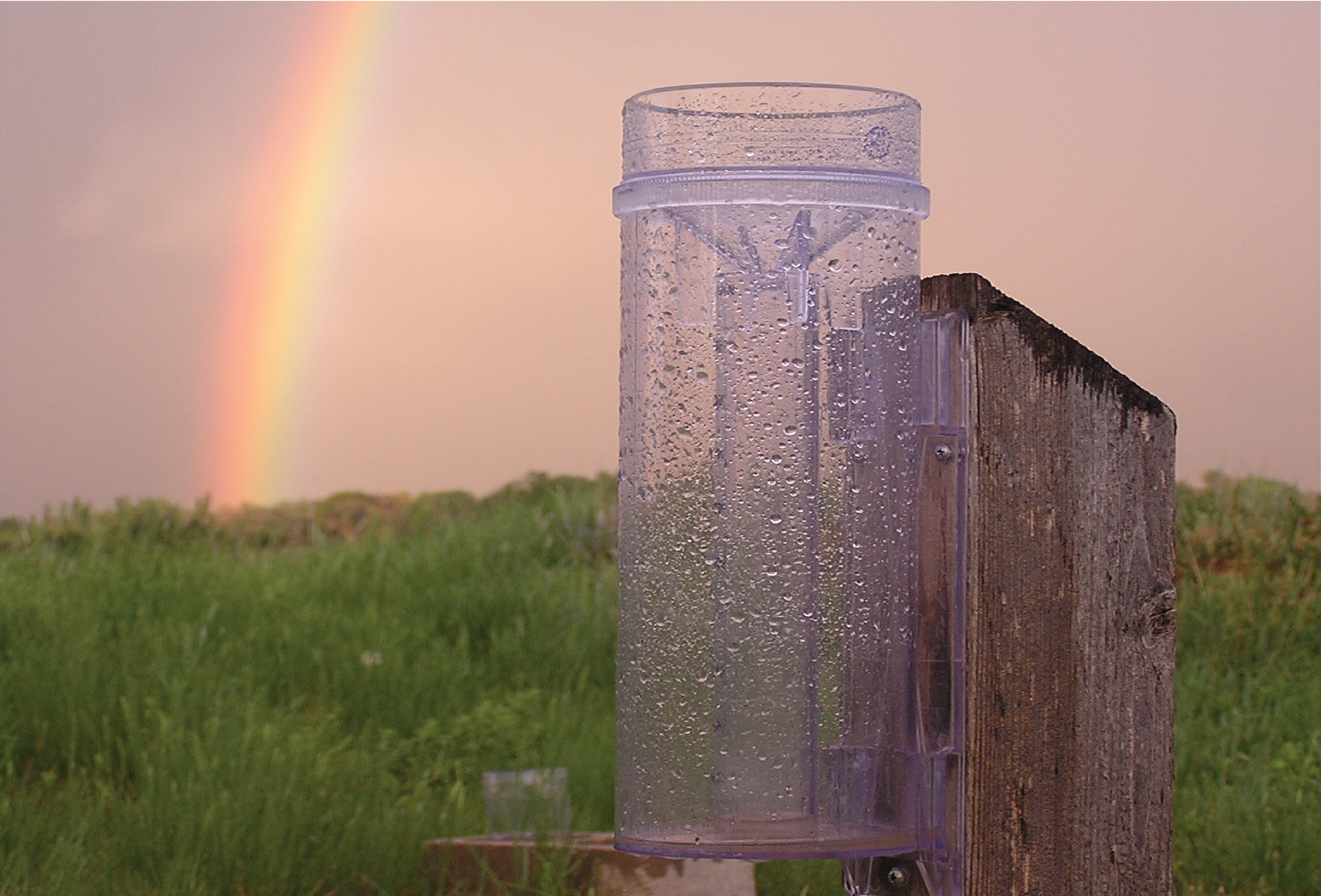rain gauge with a rainbow in background